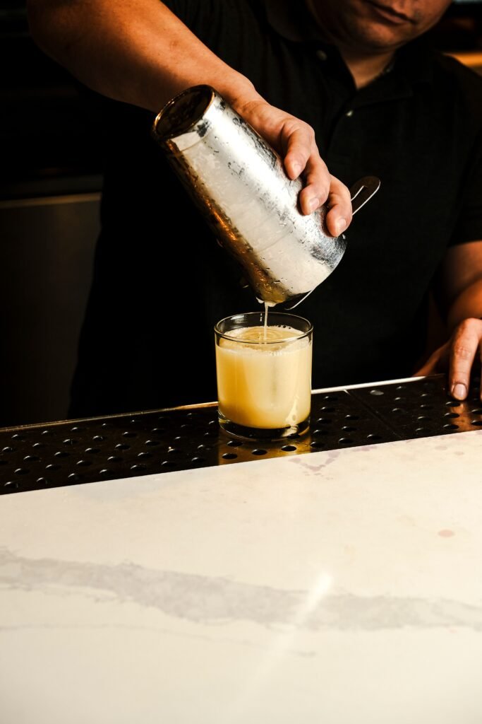Bartender sirviendo un cóctel de autor en la barra, grabado para un Reel de Instagram